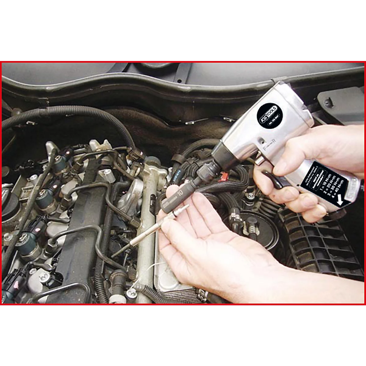 Eine Person schraubt mit einem Druckluftschrauber an einem Motor. Der Schrauber und Zündkerzen sind im Fokus.